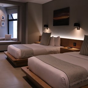 Habitación de hotel con dos camas dobles, cabeceras acolchadas y lámparas de pared, decoración elegante en tonos neutros